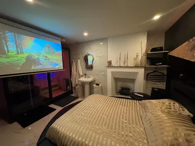 Télévision ou salle de divertissement dans l'établissement Le Cadre Noir Lux Spa, Sauna, Jacuzzi