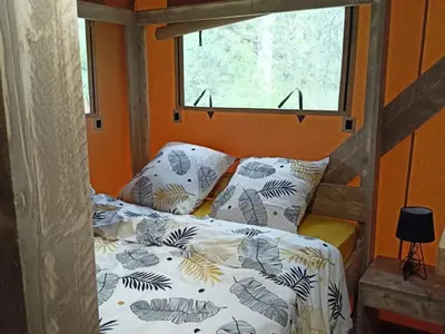 Un ou plusieurs lits dans un hébergement de l'établissement Cabane Trappeur Lodge avec Jacuzzi et Ferme Pédagogique - FR-1-410-458