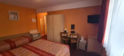 Un ou plusieurs lits dans un hébergement de l'établissement Logis Hôtel Saint-Hubert