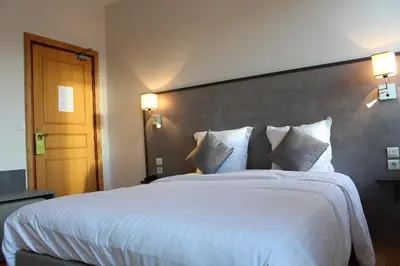 Un ou plusieurs lits dans un hébergement de l'établissement Logis Le Grand Hotel