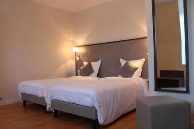 Un ou plusieurs lits dans un hébergement de l'établissement Logis Le Grand Hotel