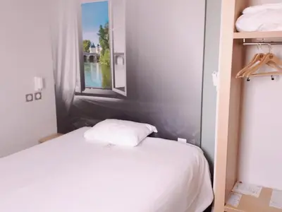Un ou plusieurs lits dans un hébergement de l'établissement B&B HOTEL Chatellerault