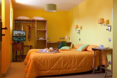 Un ou plusieurs lits dans un hébergement de l'établissement Logis hôtel Ô en Couleur