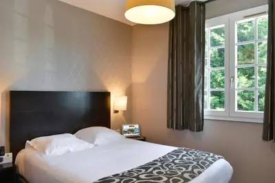 Un ou plusieurs lits dans un hébergement de l'établissement Logis Hôtel Restaurant des Châteaux