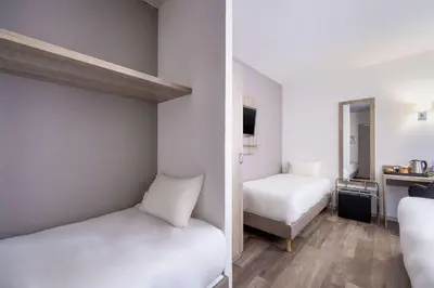 Un ou plusieurs lits dans un hébergement de l'établissement Hotel Le Circuit Le Mans