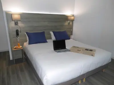 Un ou plusieurs lits dans un hébergement de l'établissement Hotel Le Circuit Le Mans