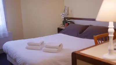 Un ou plusieurs lits dans un hébergement de l'établissement Logis Hôtel & Restaurant - Le Saint-Louis