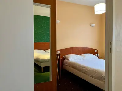 Un ou plusieurs lits dans un hébergement de l'établissement Logis Hôtel & Restaurant - Le Saint-Louis