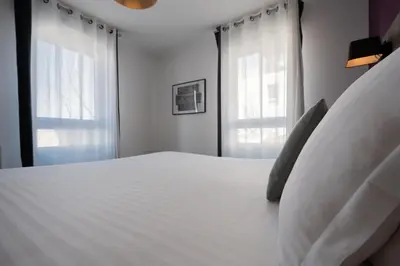 Un ou plusieurs lits dans un hébergement de l'établissement Nemea Appart Hotel Quai Victor Tours Centre