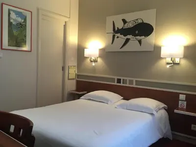 Un ou plusieurs lits dans un hébergement de l'établissement Logis Hôtel Restaurant LE MONARQUE