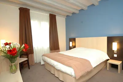 Un ou plusieurs lits dans un hébergement de l'établissement Logis Hotel La Croix Blanche Fontevraud