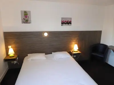 Un ou plusieurs lits dans un hébergement de l'établissement Hôtel Le Cosy Blois Villebarou
