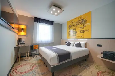 Un ou plusieurs lits dans un hébergement de l'établissement Brit Hotel Le Cottage Le Mans Sud