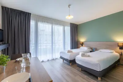 Un ou plusieurs lits dans un hébergement de l'établissement Comfort Aparthotel Le Mans