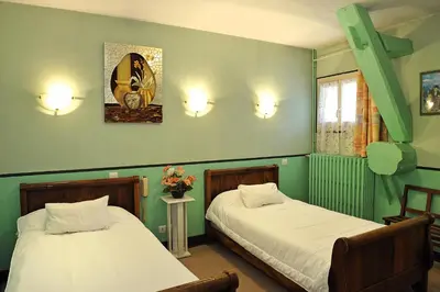 Un ou plusieurs lits dans un hébergement de l'établissement Logis Hostellerie Du Cheval Blanc