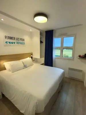 Un ou plusieurs lits dans un hébergement de l'établissement Kyriad Hôtel La Fleche