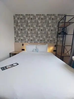 Un ou plusieurs lits dans un hébergement de l'établissement Kyriad Hôtel La Fleche