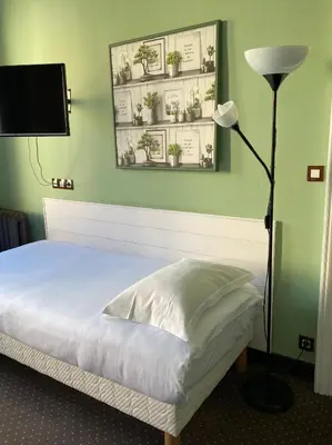 Un ou plusieurs lits dans un hébergement de l'établissement Hotel Colbert