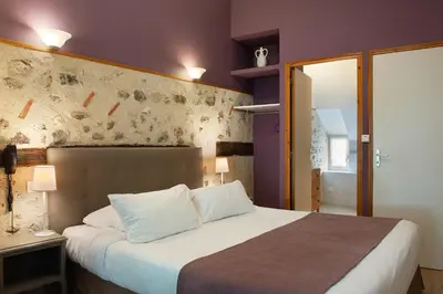 Un ou plusieurs lits dans un hébergement de l'établissement Logis Auberge Le Colombien - Hôtel et Restaurant