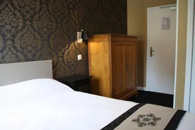 Un ou plusieurs lits dans un hébergement de l'établissement Logis Hôtel Auberge du Port des Roches