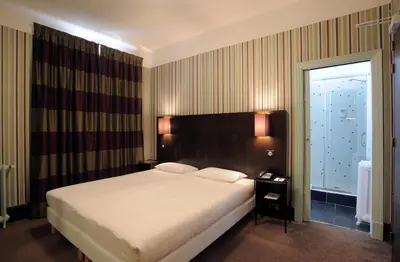 Un ou plusieurs lits dans un hébergement de l'établissement Le Grand Hotel