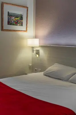 Un ou plusieurs lits dans un hébergement de l'établissement Logis Hôtel Alizéa Le Mans Nord