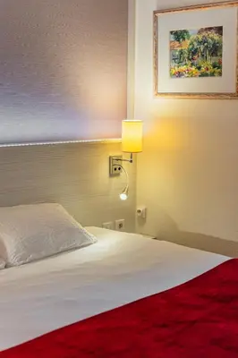 Un ou plusieurs lits dans un hébergement de l'établissement Logis Hôtel Alizéa Le Mans Nord