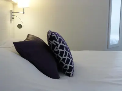 Un ou plusieurs lits dans un hébergement de l'établissement Logis Hôtel Alizéa Le Mans Nord