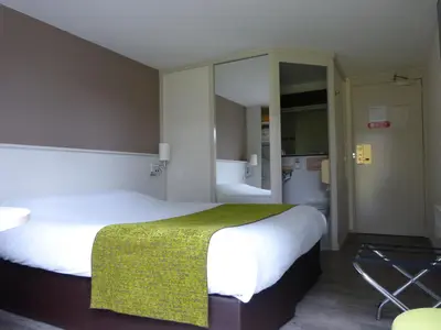 Un ou plusieurs lits dans un hébergement de l'établissement Logis Hôtel Alizéa Le Mans Nord