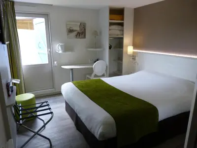 Un ou plusieurs lits dans un hébergement de l'établissement Logis Hôtel Alizéa Le Mans Nord
