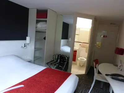 Un ou plusieurs lits dans un hébergement de l'établissement Logis Hôtel Alizéa Le Mans Nord