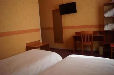 Un ou plusieurs lits dans un hébergement de l'établissement Logis Hôtel Saint Paul