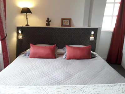 Un ou plusieurs lits dans un hébergement de l'établissement Petite Maison Romantique au calme, Cœur Historique, vue Ville et Jardin
